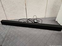 Full view of Samsung sound bar with power adapter