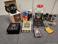 Group shot of entire lot including mugs in boxes, tarot decks, book, spices, candles, oils and pouch