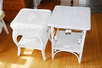 Pair of white painted wicker end tables on wooden floor, showing size and design differences