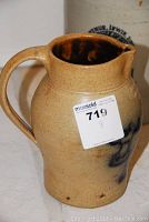 Side view of jug showing handle and overall shape with auction label attached