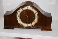 Full front view of vintage Forestville mantel clock on white shelf