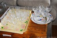 Lot showing all crystal glasses arranged on two trays on a wooden table