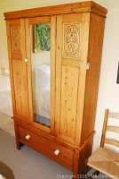 Front view of entire armoire showing mirrored central door and side panels
