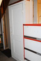 Front view of tall antique chimney cabinet, white painted surface, showing door and hardware.