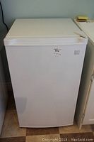 Front view of the white Kenmore mini fridge showing overall appearance.