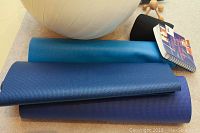 Close-up of yoga mats and exercise ball with various items visible