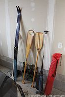 Photo of Karhu cross country skis, wooden paddles, plastic and aluminum paddle, folding camp chair in red bag