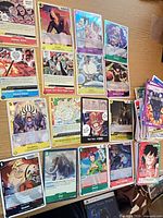 Overview of 14 One Piece cards laid out with additional stack of commons