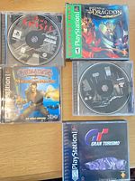 Overview of five PS1 games laid out with cases and some discs visible