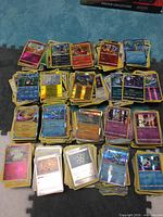 Stacks of assorted Pokémon cards spread out, showing variety and foil finishes