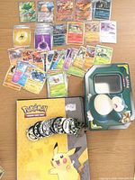 Overall lot showing cards, binder, coins, Snorlax tin