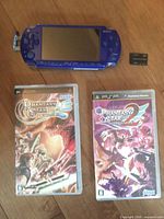 Full lot: blue PSP console, two Phantasy Star Portable game cases, Memory Stick