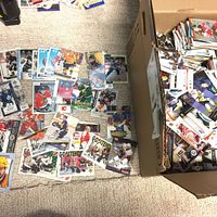 Overhead view of scattered hockey cards on carpet next to box