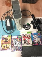 Group shot: console, power brick, Kinect, controller, five games displayed