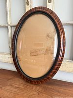 Front view oval tiger stripe wood frame with convex glass