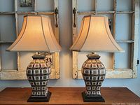 Both matching Bombay Company urn table lamps with shades displayed on table