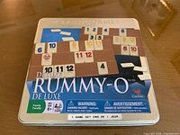 Tin lid showing Cardinal Deluxe Rummy-O graphics