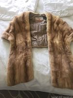 Front view of light brown mink stole with satin lining visible