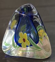 overall view of triangular clear and blue art glass bud vase with yellow floral design