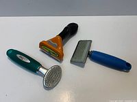 Three grooming tools laid out on white surface
