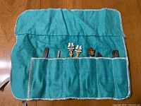 Turquoise utensil roll holding multiple souvenir utensils