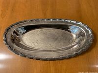 Full view of oval silver-plated tray showing etched center and scalloped rim