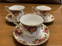 Three teacup and saucer sets displayed together