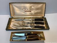 Carving set in Debonair box above steak knives in plain box
