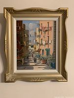 Framed cityscape painting showing full artwork and ornate frame