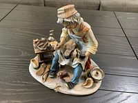 Full view of porcelain cobbler figurine on base