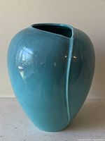 Front view of turquoise glazed ceramic vase showing angled mouth and glossy finish