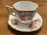 Teacup on saucer showing floral pattern and gold trim