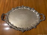 Top view of ornate oval silver-plate serving tray with handles