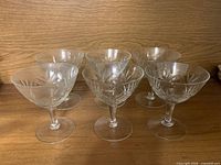 Six cut crystal cocktail glasses on wooden surface
