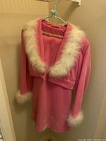 Pink velvet cropped jacket with white faux fur trim over matching dress
