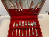 Open storage box showing knives in lid and rest of flatware in lower tray