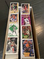 Open 2-row card box showing assorted 1990s basketball cards on left and right rows, visible players include Shawn Kemp and Charles Oakley