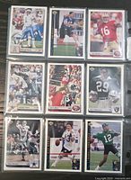 Front view of nine Upper Deck football trading cards in a plastic sleeve, showing all players listed