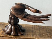 Left side view of carved hand on lotus base