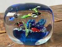 Front view of glass paperweight showing scuba diver, fish, coral