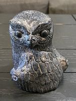 Front view of textured resin owl sculpture, showing overall form and feather detail
