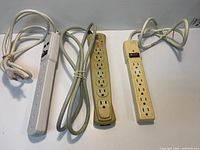 Three power strips showing outlets, cords, switches, overall condition