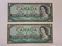 Front view of both 1954 $1 banknotes showing serial numbers and portrait