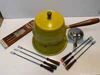 Full set view: pot on stand with burner, boxed forks and five loose forks