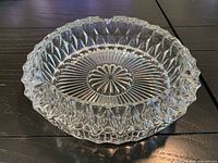 Overview of clear glass ashtray showing starburst base and diamond-cut sides