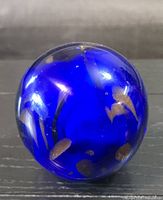 Front view of cobalt blue glass paperweight orb showing gold flecks
