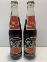 Front view of two sealed 1981 75th Circleville Pumpkin Show Coca-Cola 12 oz bottles