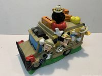 Front angled view showing characters and rooftop luggage on safari vehicle coin bank