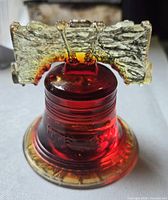 Side view showing amber-to-red glass insulator with clear-amber saddle top