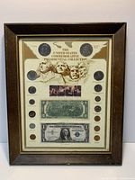 Overall view of framed collection showing coins, notes and stamp